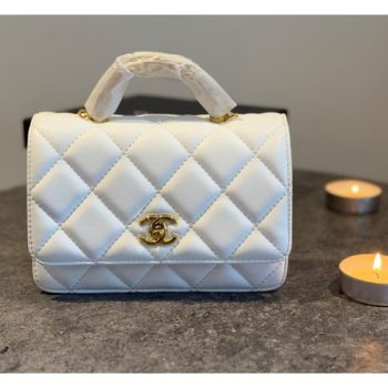 Chanel Mini Top Handle Flap Bag in white lambskin leather with gold-tone hardware, featuring classic quilting, a CC turn-lock closure, and a versatile top handle design.